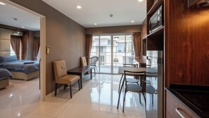 Una habitación de hotel moderna con cama, comedor y cocina.