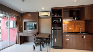Una cocina moderna con una mesa de comedor, sillas, un refrigerador, un microondas y una cafetera.