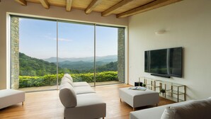 A modern living room with a large sliding glass door, a flat-screen TV, and a minimalist design.