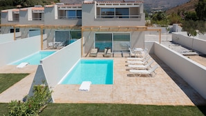 Un hôtel moderne doté de deux piscines, d’un espace extérieur aménagé et offrant une vue sur les montagnes.