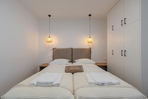 Un lit double avec deux tables de chevet, une tête de lit et une armoire à deux portes.