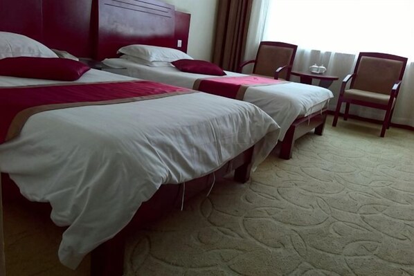 A hotel room with two beds, a small table, and two chairs. - Shang Yuan Hotel (Habahe)