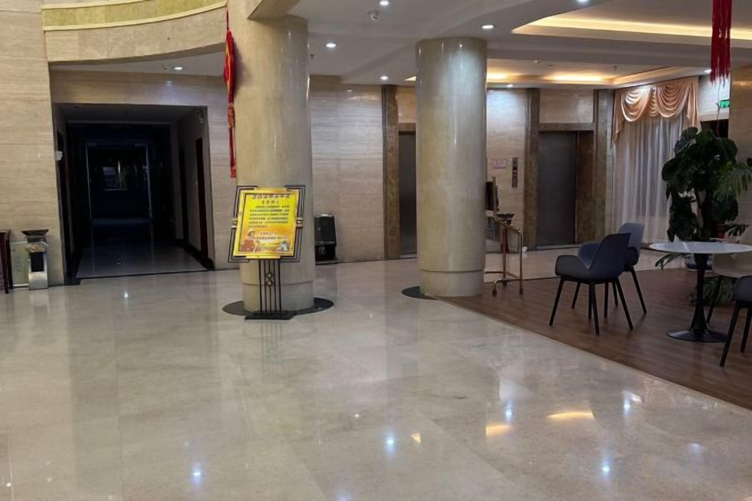 A lobby with a reception desk, a seating area, and a large pillar.
