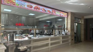 A restaurant with a food display and kitchen area. - Shang Yuan Hotel (Habahe)