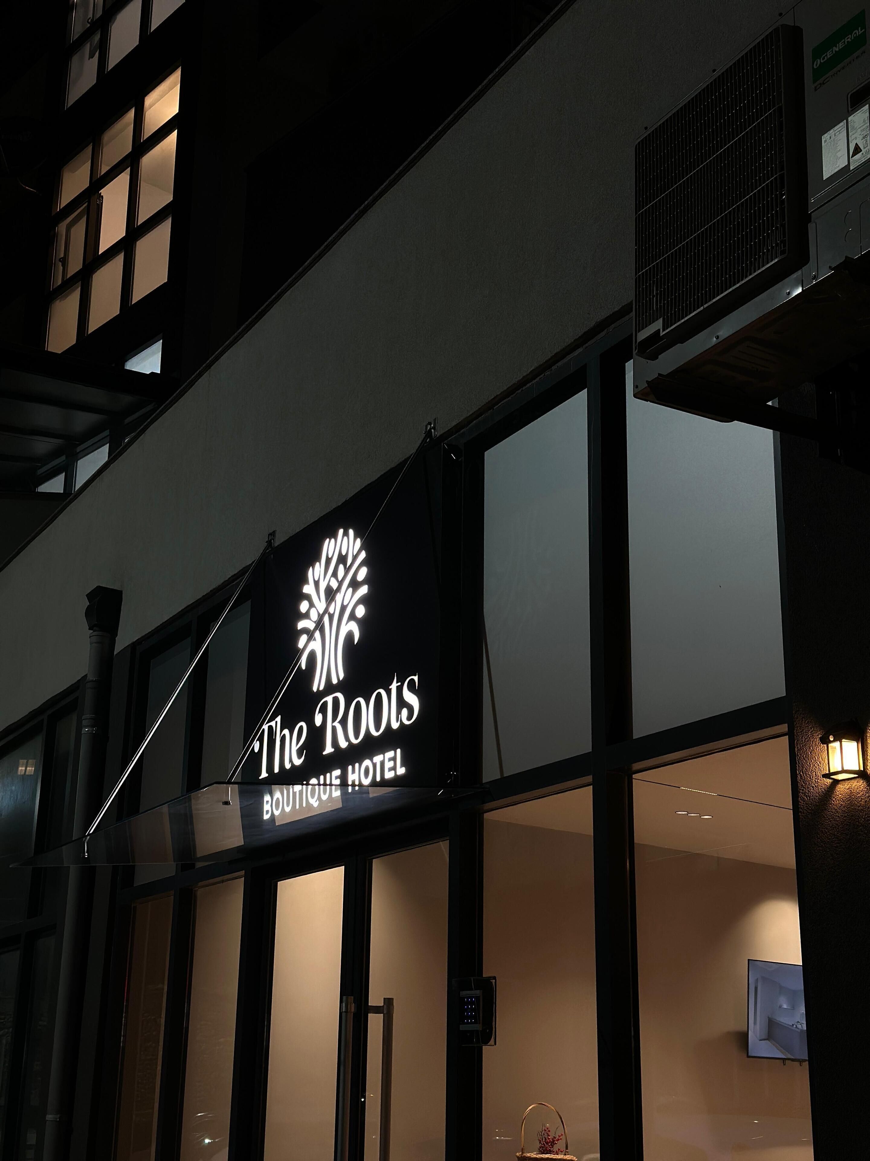 Een gebouw met een bord waarop staat: The Roots Boutique Hotel.