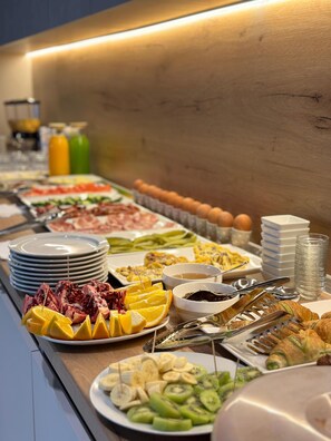 A buffet with various food items including fruits, vegetables, and meats.