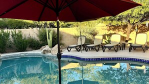 A circular pool with a red umbrella, surrounded by lounge chairs and a cactus. - Prime Location! North Scottsdale Retreat - 1 Level Home w/Private Pool (Scottsdale)