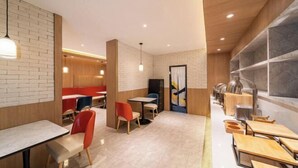Un interior de restaurante moderno con paredes de ladrillo, detalles de madera y diversas opciones de asientos, incluidas mesas y sillas.