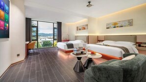 A hotel room with a large bed, a sofa, a small table, and a view of the city. - Lijiang Yueyou International Hotel (Lijiang Old Town Branch (Lijiang)
