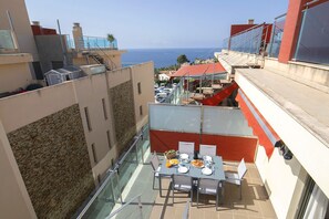 A rooftop terrace with a table set for dining, overlooking a coastal view. - ATICO BORUMBOT VISTA PISCINA (Calpe)