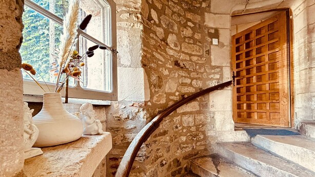 A stone staircase leading to a wooden door, with a window and a vase with dried plants on the left. - Large, comfortable apartment right in the center of town, ideal for families. (Villefranche-de-Rouergue)