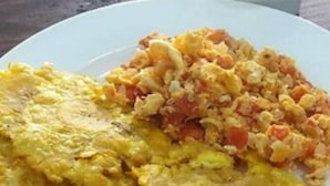 A plate with scrambled eggs and a side of diced vegetables. - Hotel Puerto Vigia Inn (Cartagena)