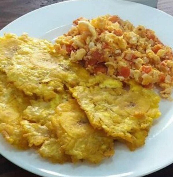 A plate with scrambled eggs and a side of diced vegetables. - Hotel Puerto Vigia Inn (Cartagena)