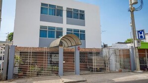 A modern building with a white facade and multiple windows. - Hotel Puerto Vigia Inn (Cartagena)