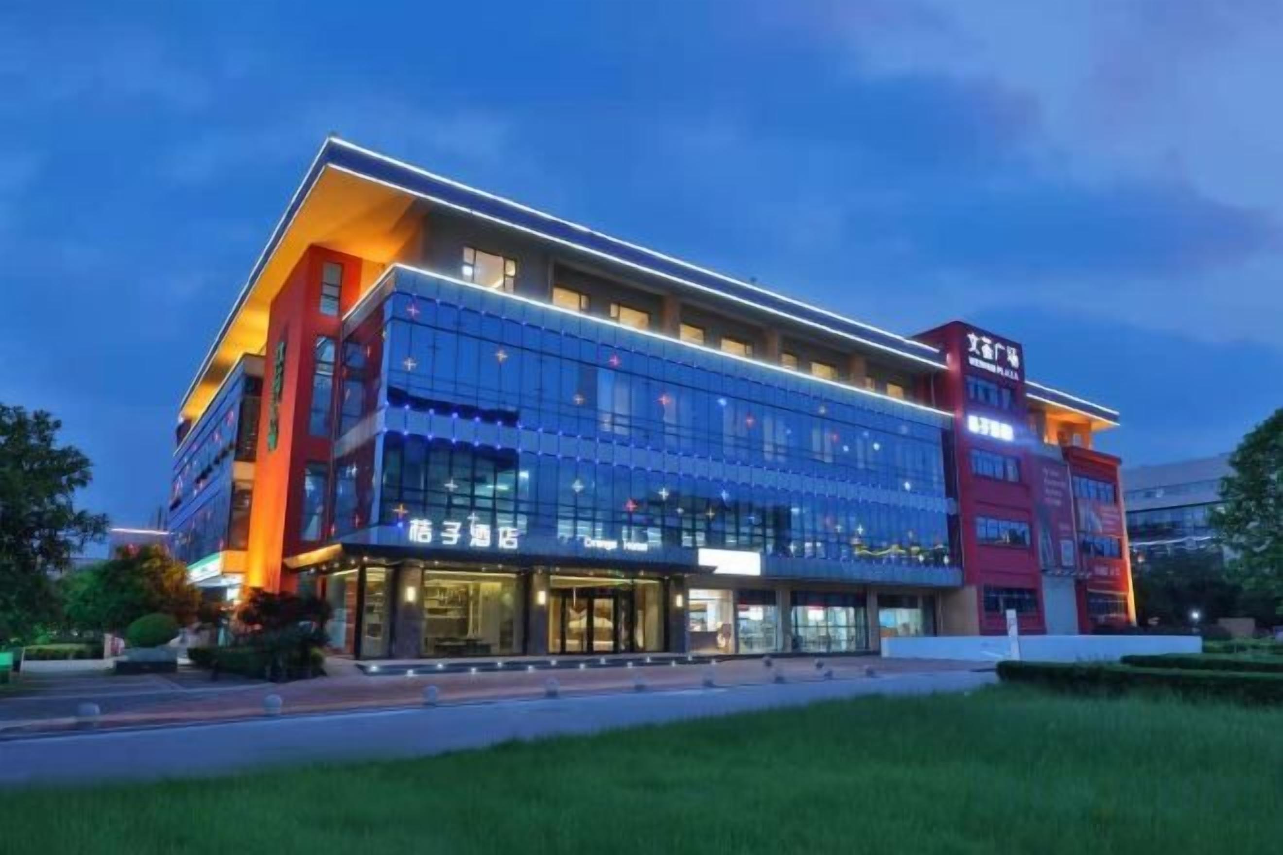 A multi-story hotel with a modern design, featuring a prominent entrance and a large glass facade.