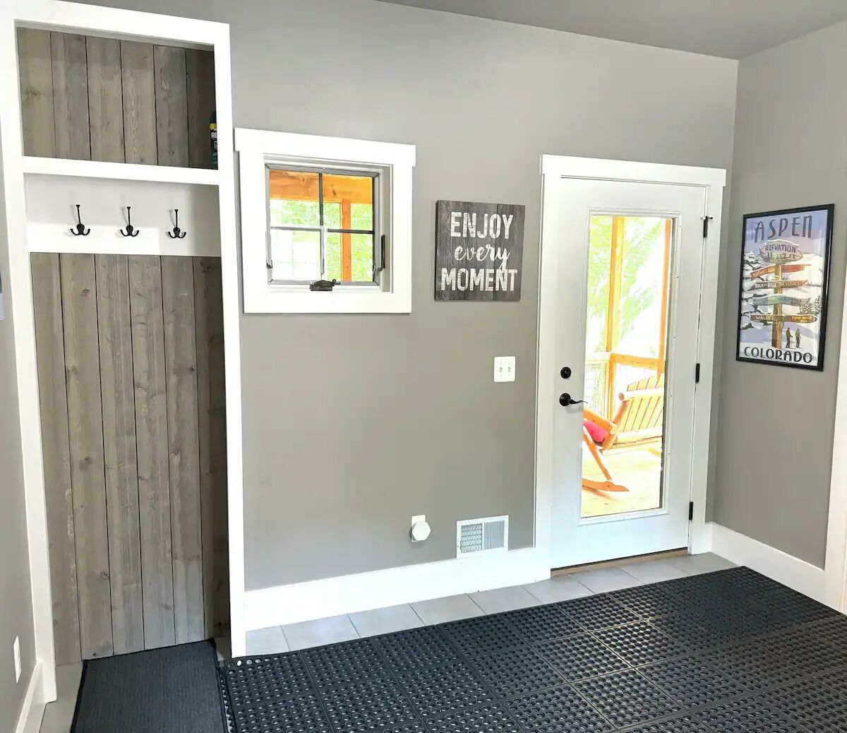 Un couloir avec une porte en bois, une petite fenêtre et une affiche aux messages inspirants.