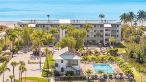A hotel with a pool, palm trees, and a view of the ocean. - All New! Gulf Front! High End! Pelicans Roost 101 on Sanibel Island (Sanibel)
