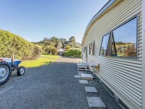 Enjoy panoramic views of the surrounding landscape from the large windows of this caravan, set amidst lush greenery and rolling hills.