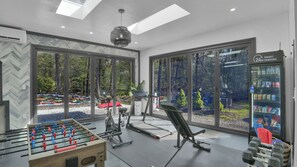 A gym with exercise equipment, a foosball table, and a vending machine.