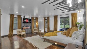 A modern living room with a fireplace, a large TV, and a sofa.