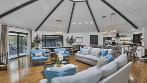 A spacious living area with a high ceiling, a dining area, and a kitchen with modern appliances.