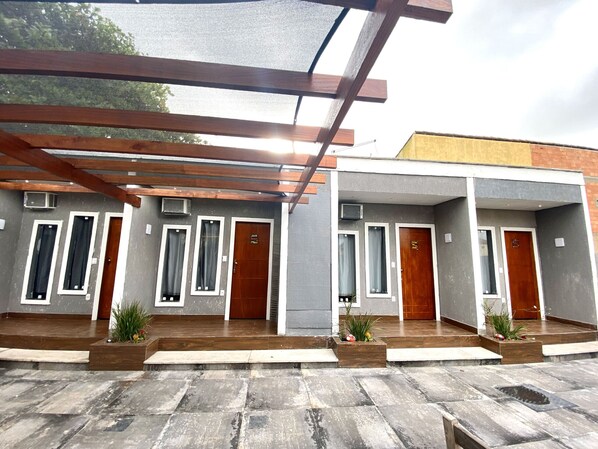 A modern building with two-story structures, each featuring a wooden door and a window with a curtain.