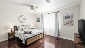 A bedroom with a bed, a clock, a ceiling fan, a window with curtains, and a painting on the wall. - Fab 2B/2Bth, All New  & Easy Access  to US99 (Fresno)