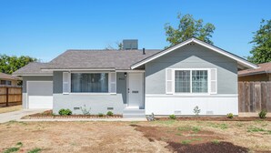 A single-story house with a front garage, a small front yard with landscaping, and a clear blue sky. - Fab 2B/2Bth, All New  & Easy Access  to US99 (Fresno)