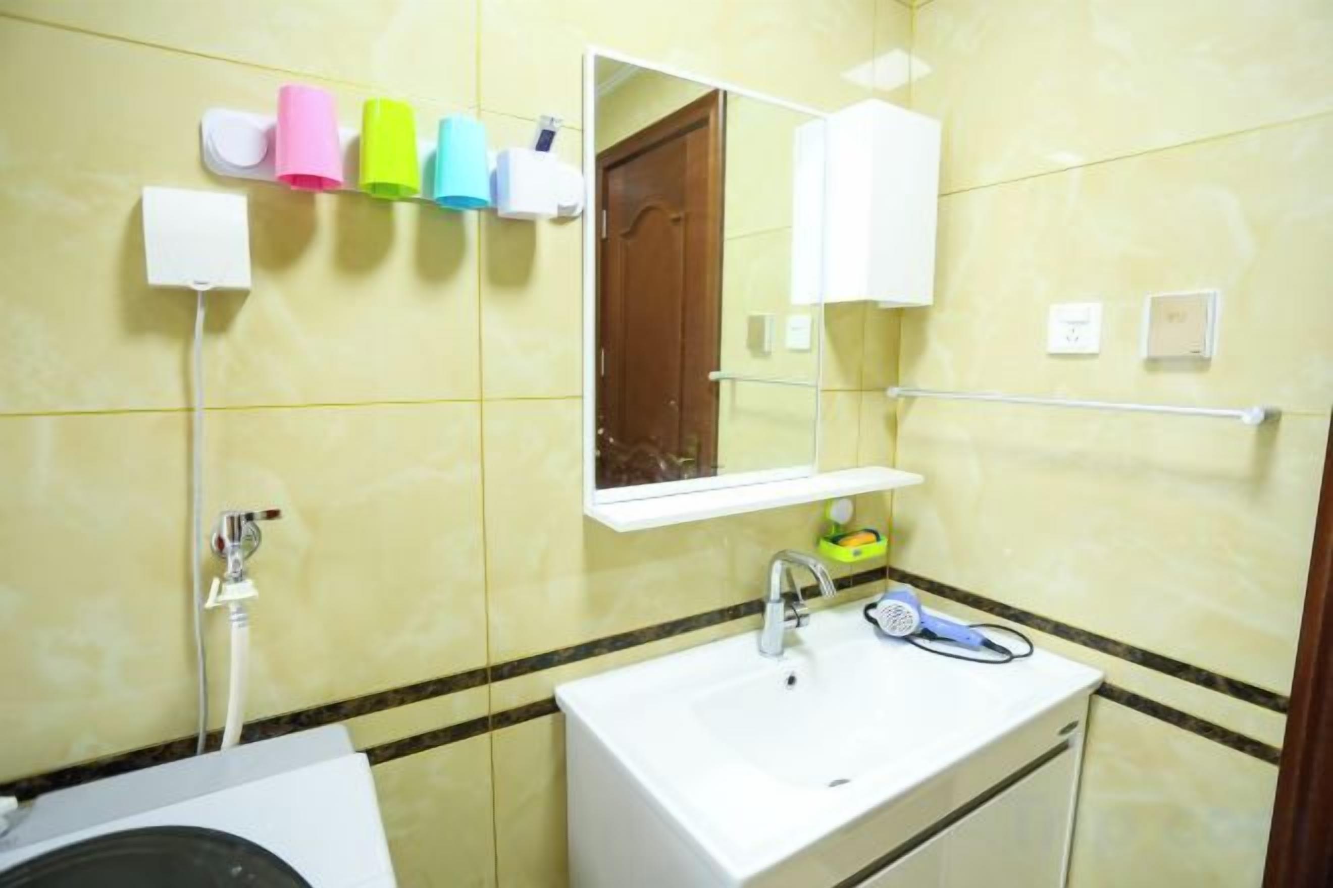 Een badkamer met een wastafel, spiegel en handdoekhouder.