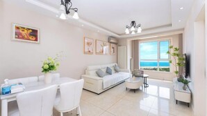 Een moderne woonkamer met een eethoek, een bank en uitzicht op zee.