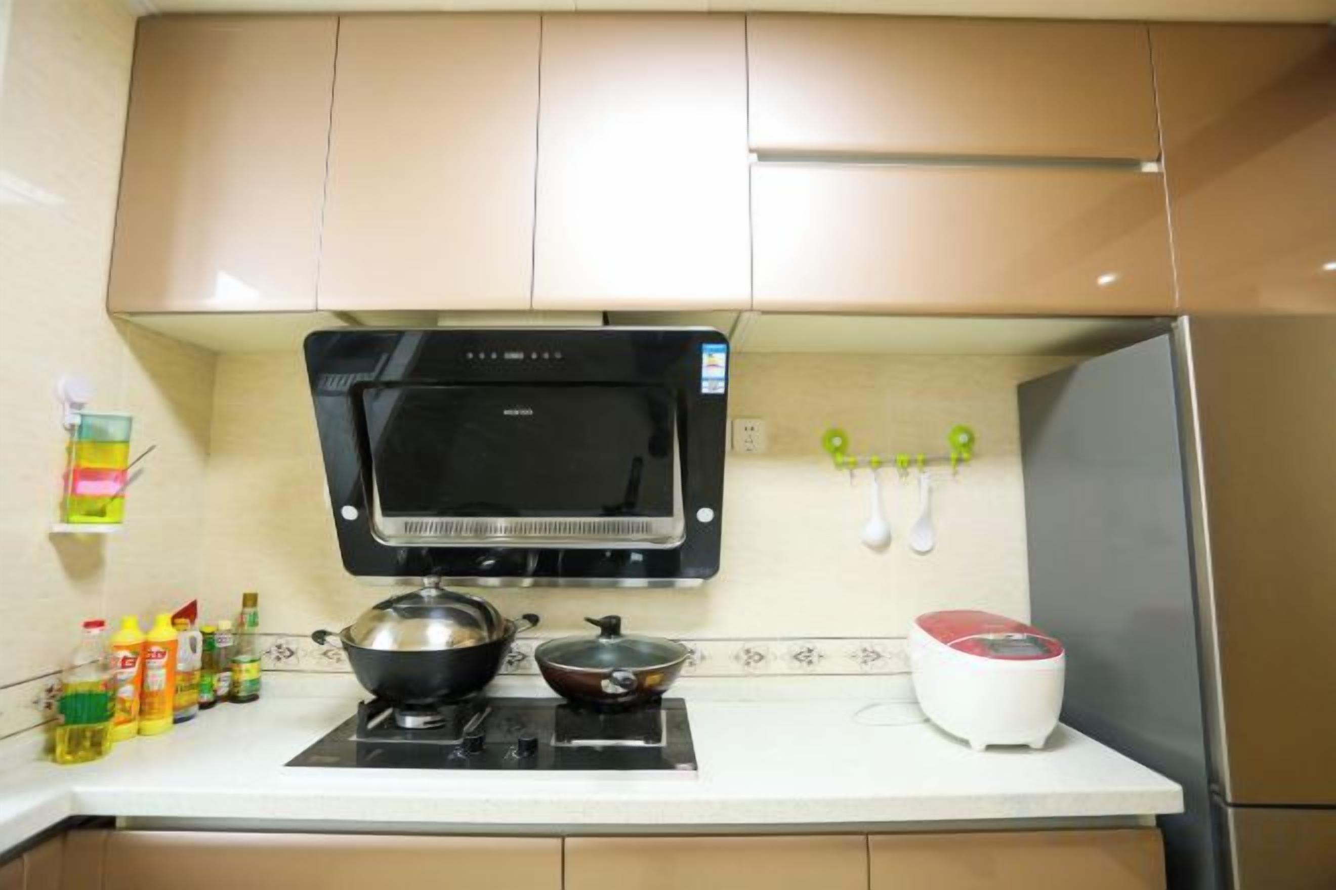 A kitchen with a microwave, stove, and a red appliance on the counter.