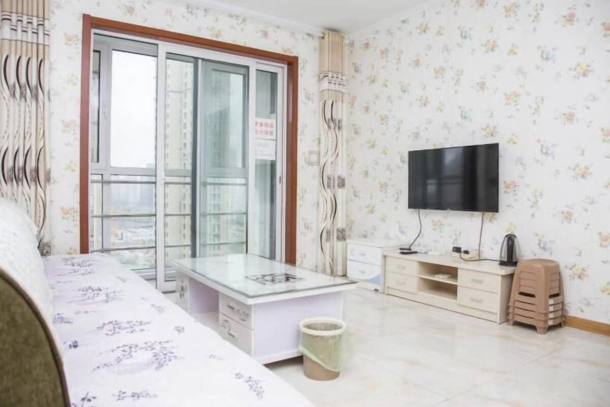 Ein Hotelzimmer mit Bett, Fernseher, Schreibtisch und Fenster mit Blick.