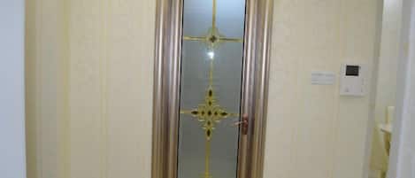 Une porte dotée d’un panneau de verre décoratif et d’une poignée.