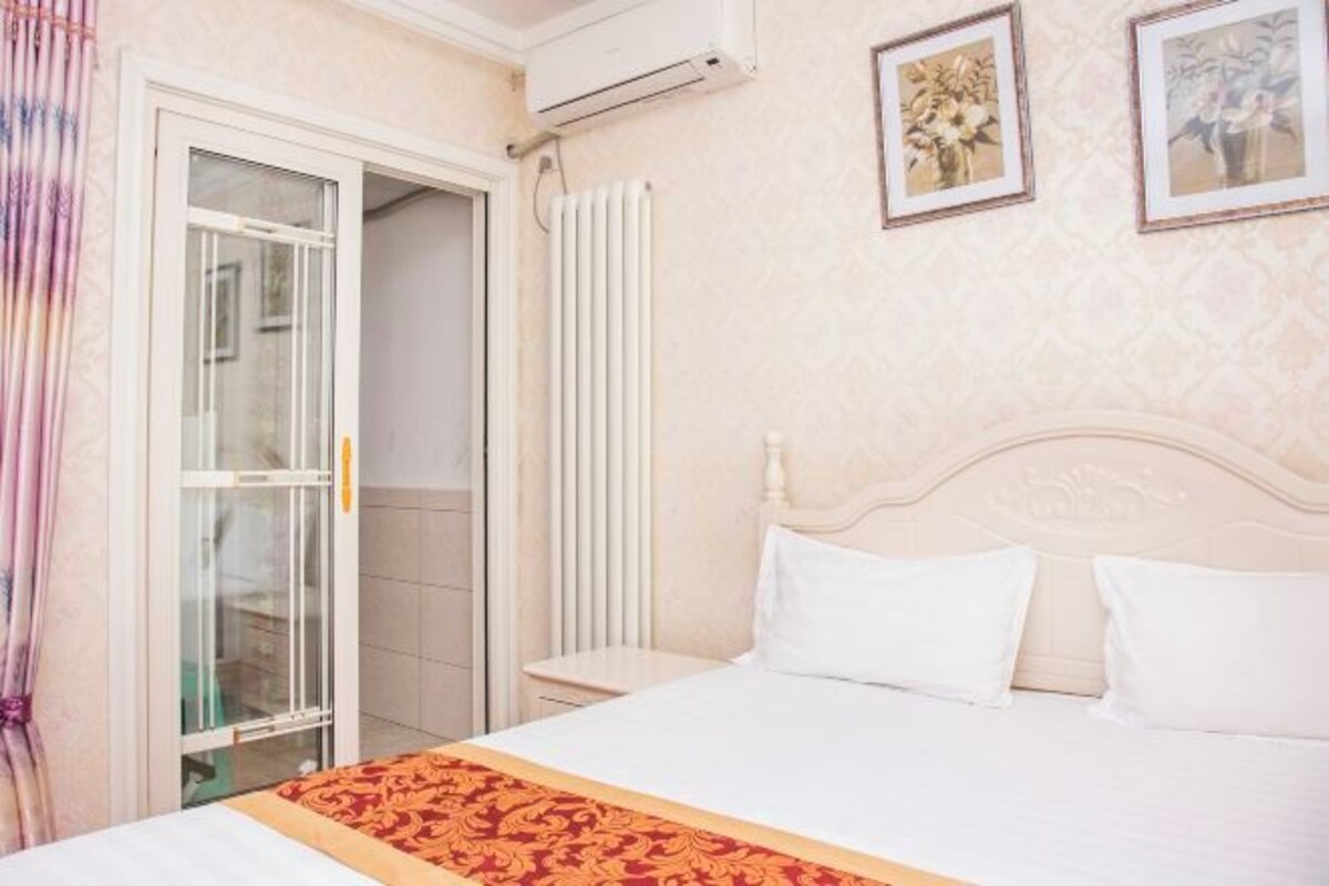 Une chambre d’hôtel avec un lit, un radiateur et une porte donnant sur un balcon.