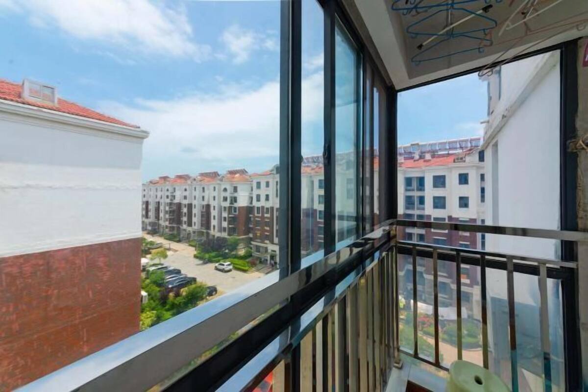 Ein Balkon mit Blick auf angrenzende Gebäude und einen klaren Himmel.