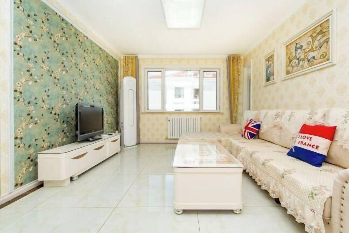 Ein Wohnzimmer mit einer Couch, einem Fernseher und einer Heizung.