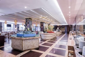 Un hall d’entrée spacieux doté d’un îlot central, de coins salon et d’un design de plafond moderne.