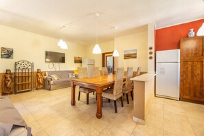 Relax in this spacious living area with a large dining table and modern kitchen.