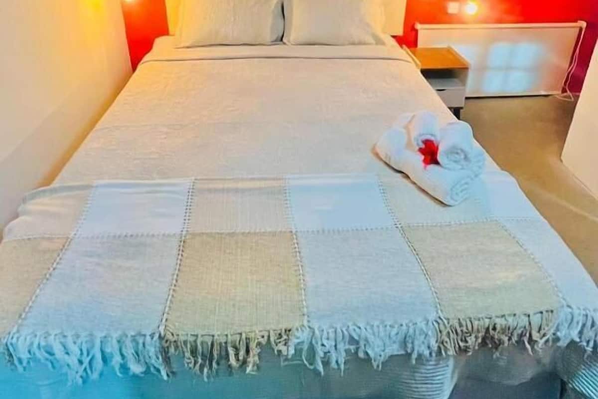 Ein Bett mit Decke, Kissen und Handtuch.