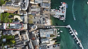 An aerial view of a coastal town with a marina, residential buildings, and a dock.