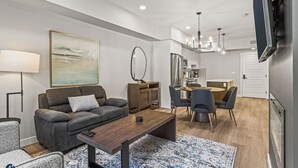 Ein modernes Wohnzimmer mit Sofa, Couchtisch und Essbereich.