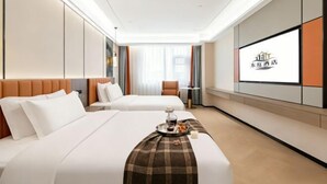 Una habitación de hotel con dos camas, televisión y una bandeja para el desayuno.