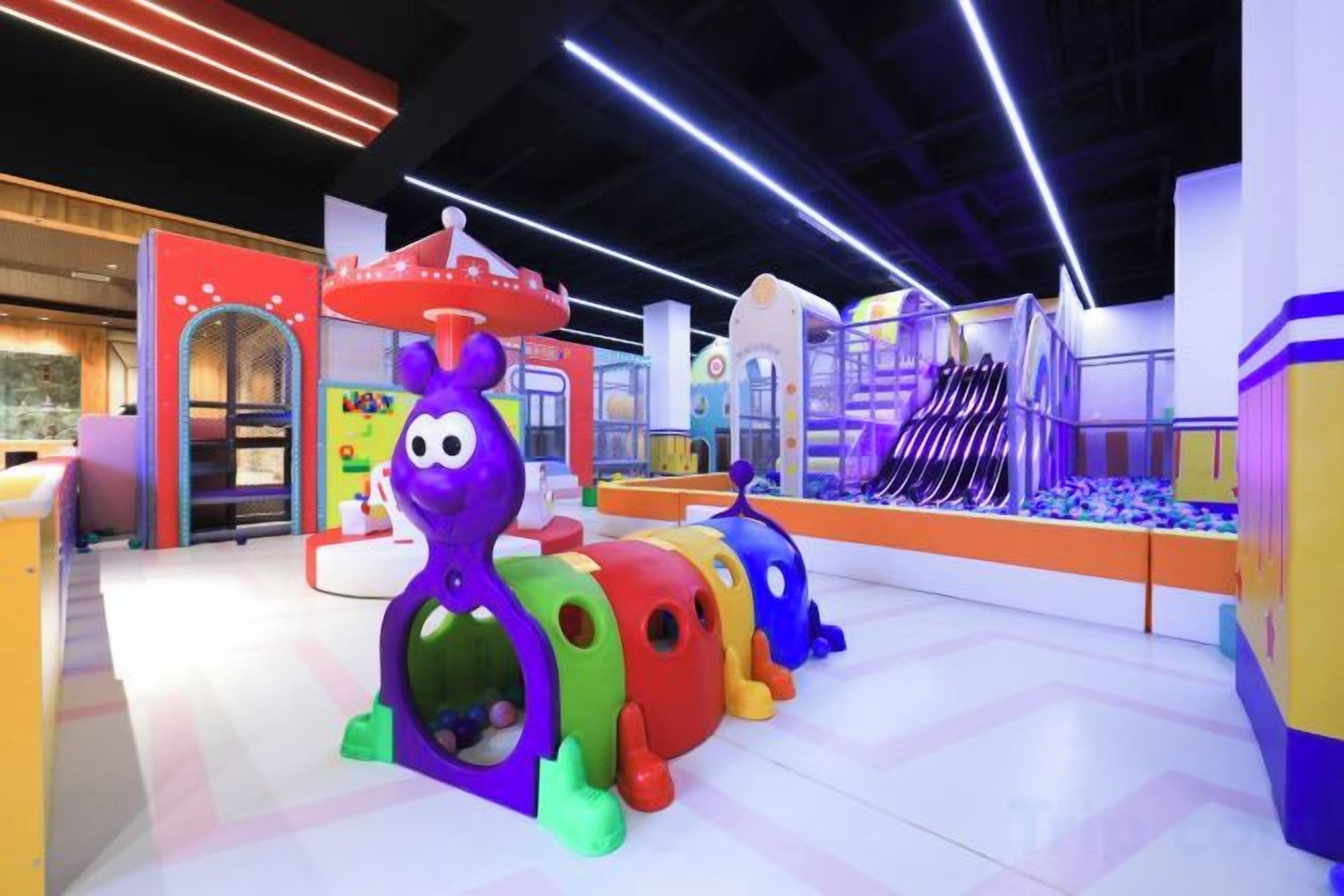 Zona de juegos infantiles con estructuras coloridas y un tobogán.