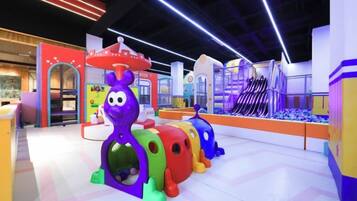 Zona de juegos infantiles con estructuras coloridas y un tobogán.