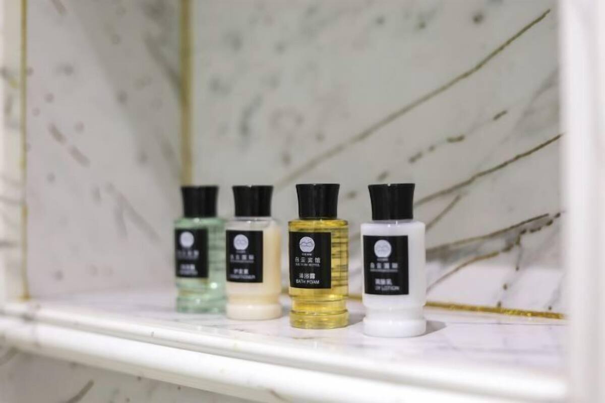 Une étagère avec quatre bouteilles de produits de bain.