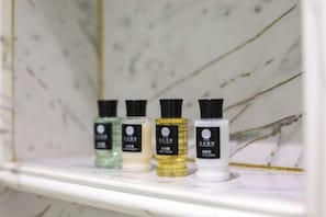 Una estantería con cuatro botellas de productos de baño.
