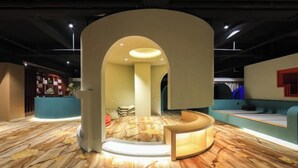 Een modern interieur met een centrale boog, een receptiebalie en een patroon vloer.