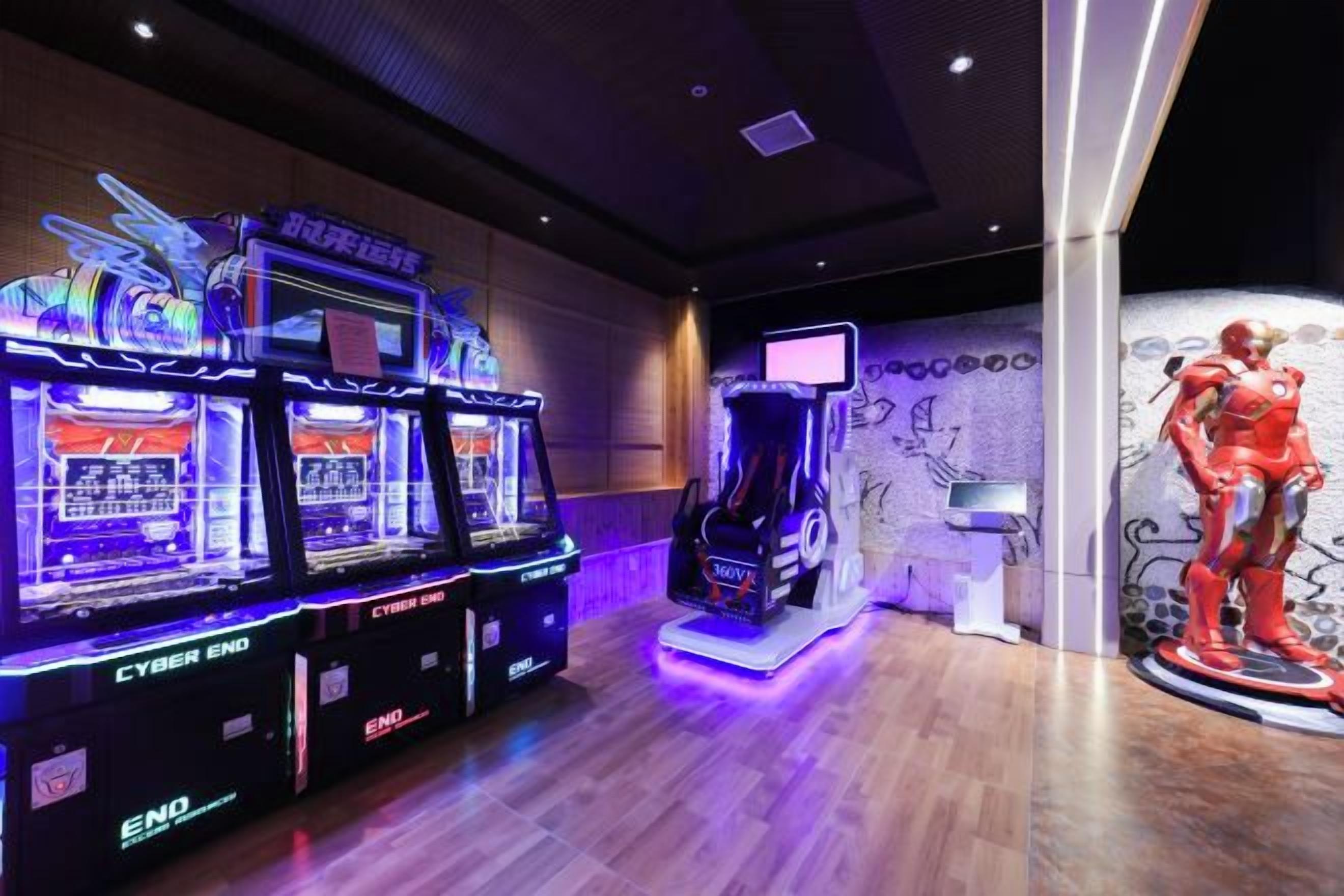 Arcade machines, a statue, and a wall with graffiti.