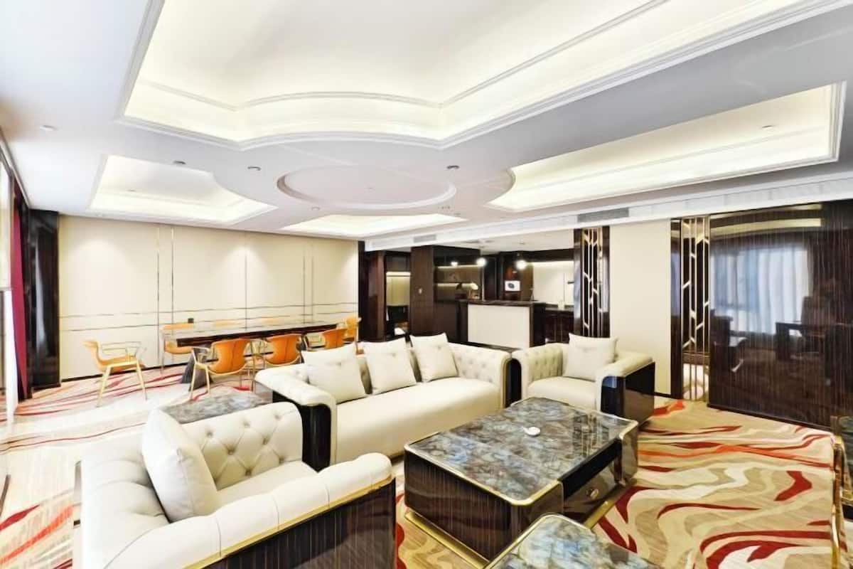 Une chambre d’hôtel moderne avec un canapé d’angle, une table basse et un coin repas.