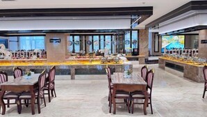 Un comedor amplio con suelo de mármol, varias mesas y sillas.